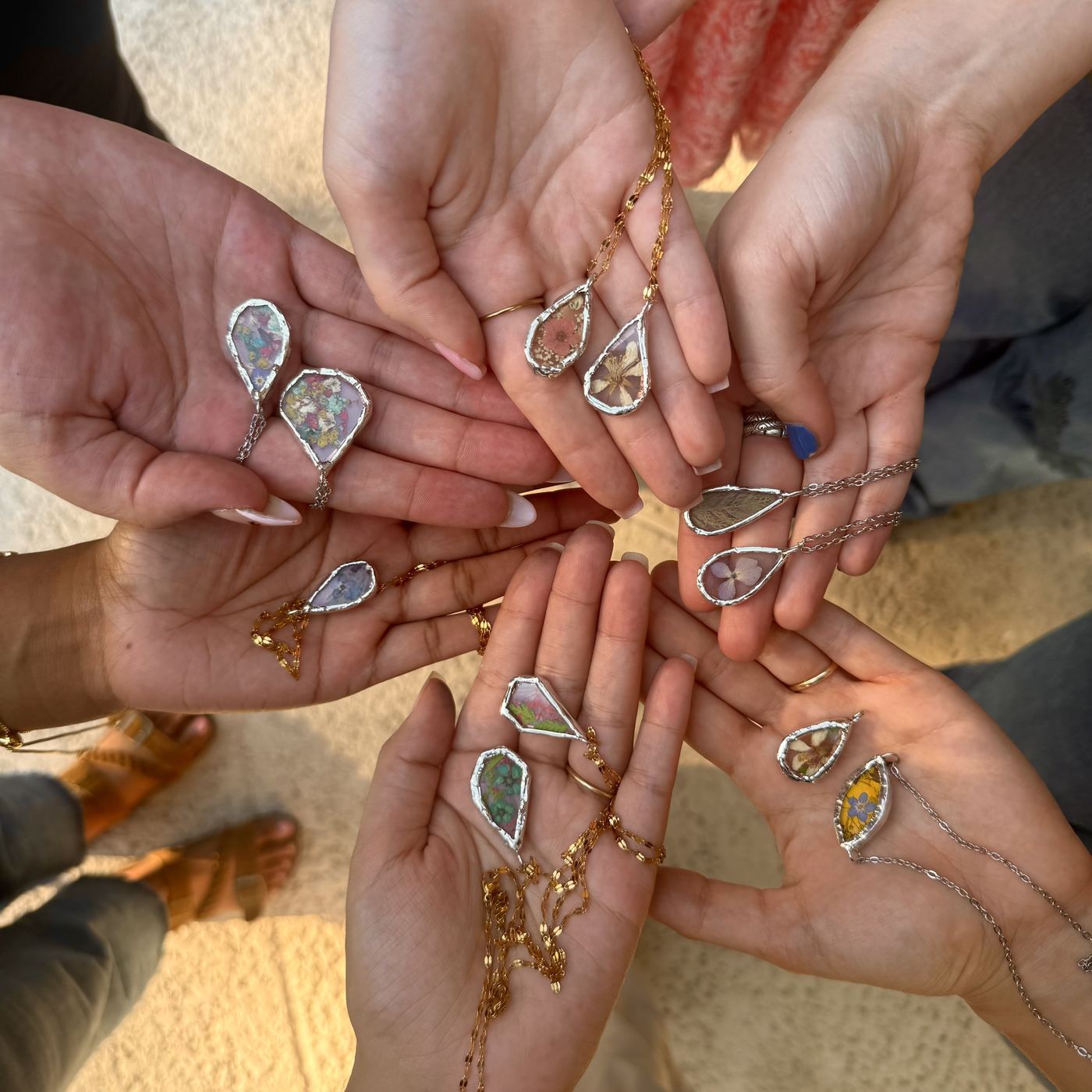 Workshop participants holding handmade jewelry